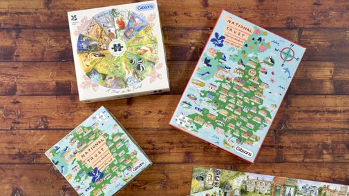 Three puzzle boxes sit on a wooden floor